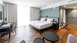 Una habitación de hotel moderna con una cama grande, un escritorio y un rincón de comedor.