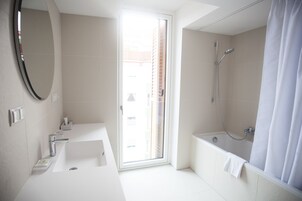 Uma casa de banho moderna com uma janela ampla, banheira e chuveiro.