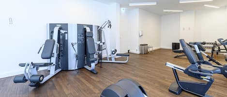 A gym with cardio machines, weight machines, and a bench press.
