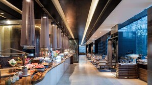A modern hotel lobby with a long reception counter, a dining area, and a view of the outdoors. - Hilton Mexico City Santa Fe (Mexico City)