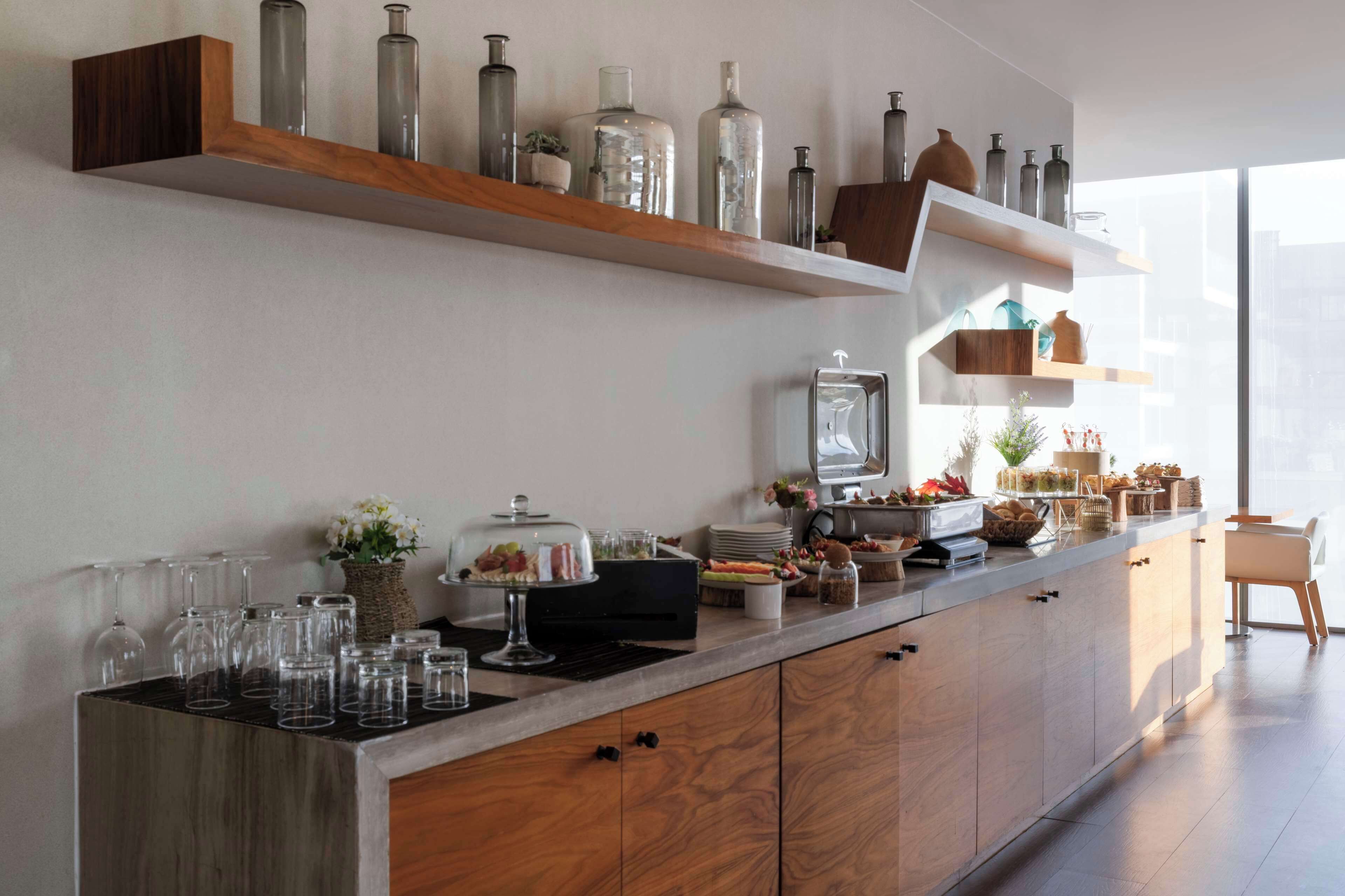 A modern kitchen with wooden cabinets, a marble countertop, and various kitchen appliances.