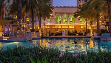 Una piscina al aire libre, sillones reclinables de piscina