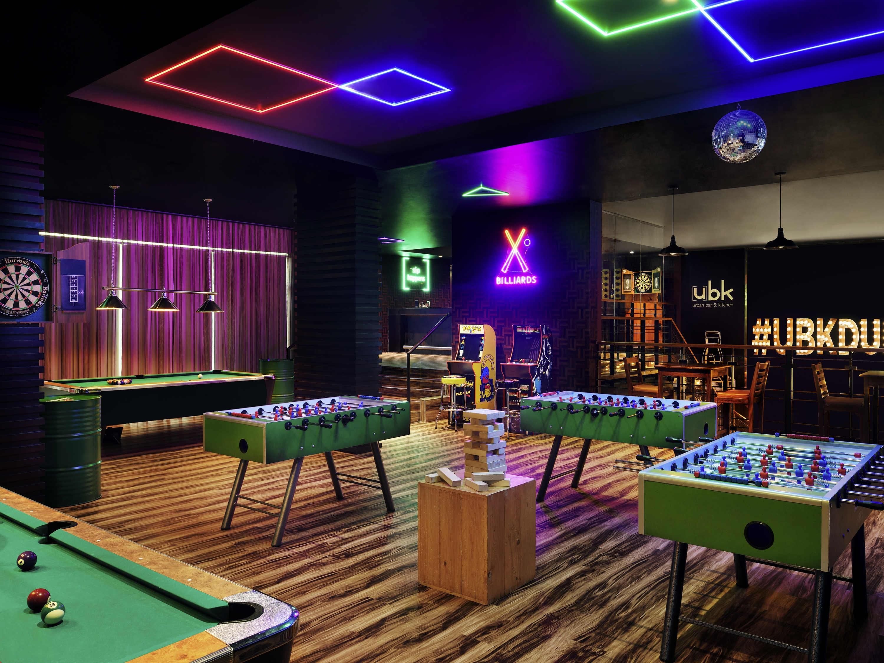 Une salle de billard équipée de tables de baby-foot, d’un jeu de fléchettes et d’une table de billard.