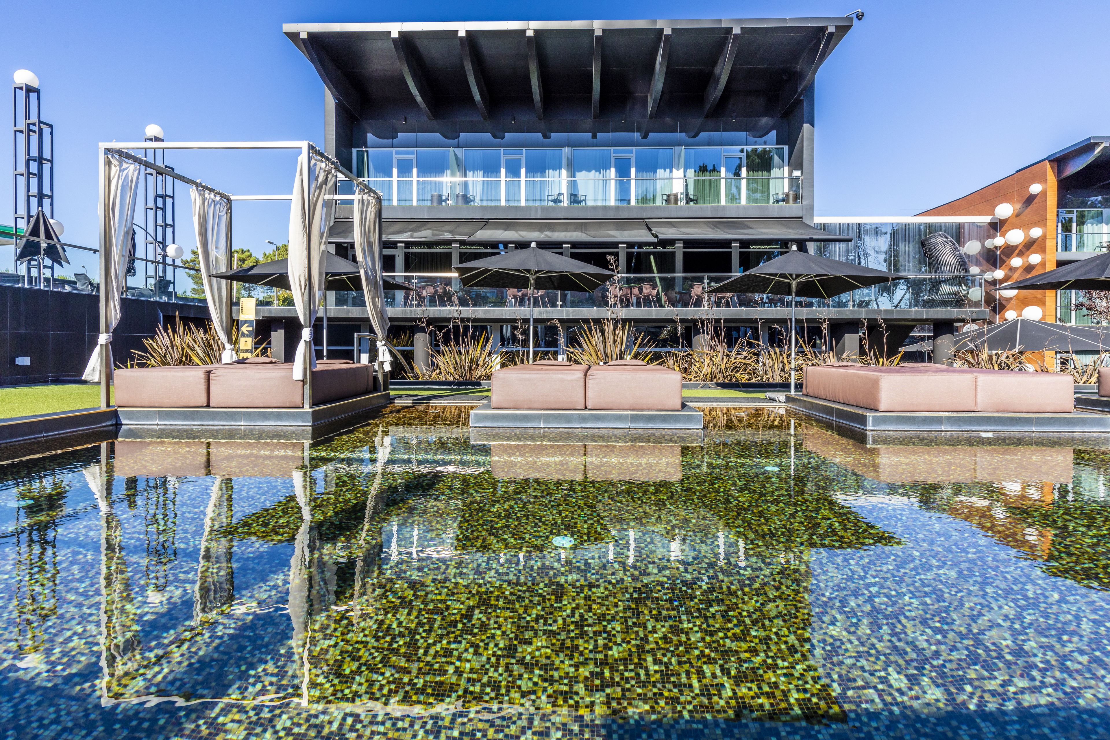 A modern building with a pool in front.