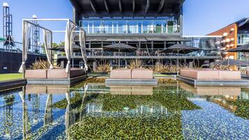 A modern building with a pool in front.