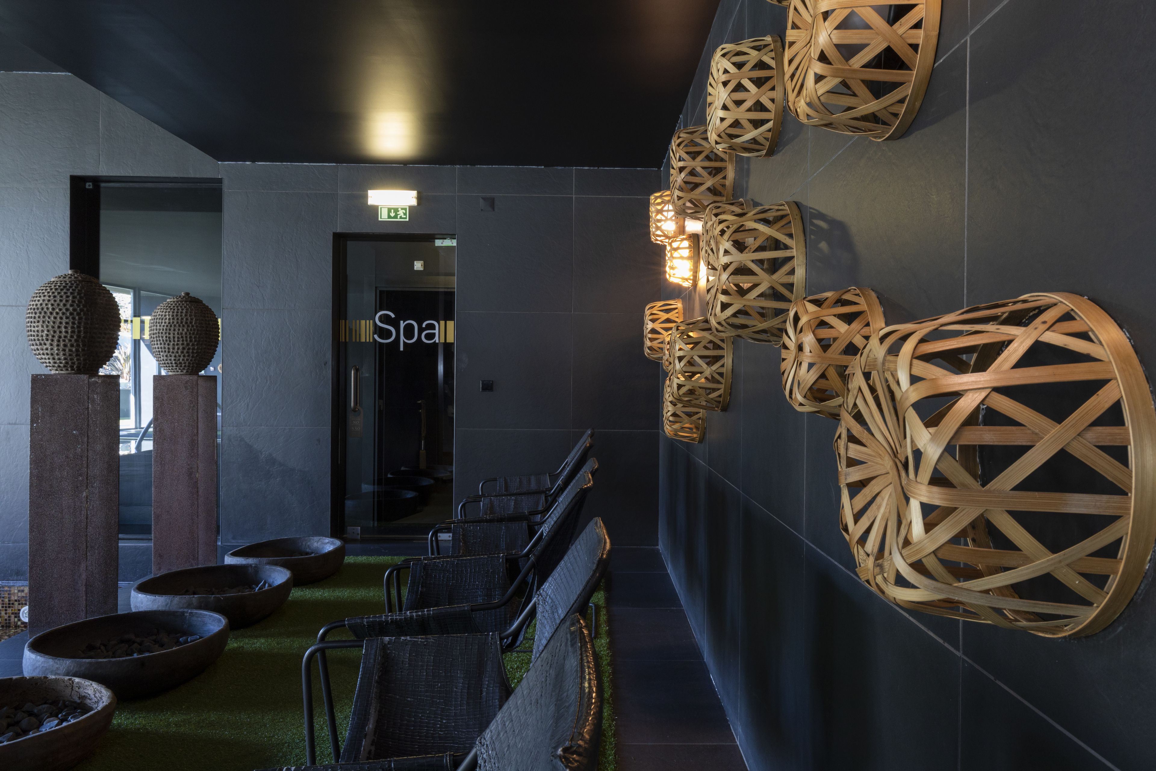 A modern lobby with a reception desk, seating area, and decorative wall elements.