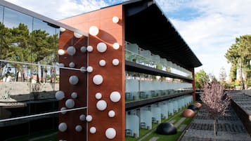 A modern building with a wooden facade and white spherical decorations. It features multiple levels with glass railings and outdoor seating areas.