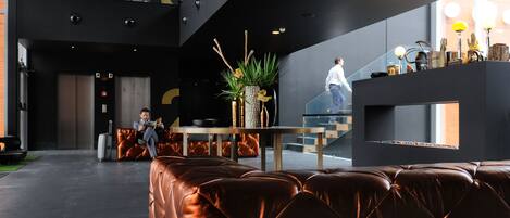 Un vestíbulo moderno con asientos de cuero, una escalera y una recepción decorada.