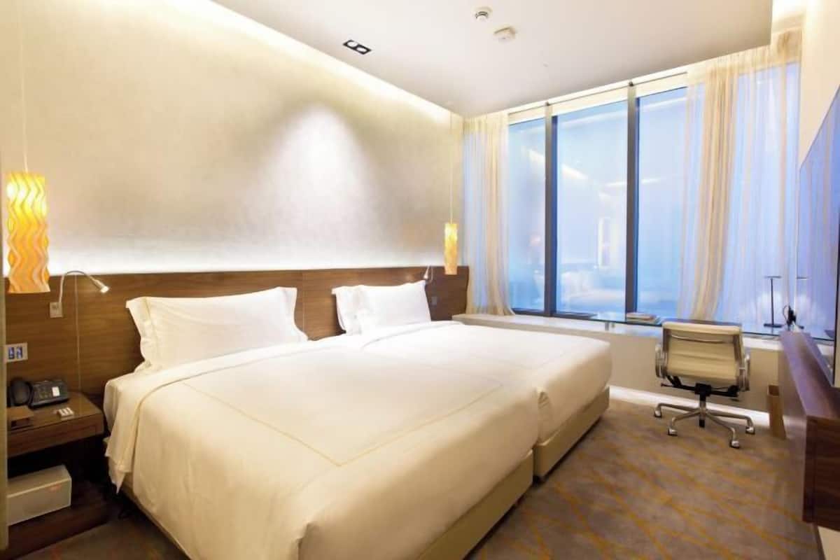 Une chambre d’hôtel avec un grand lit, des tables de chevet, un bureau et une chaise.