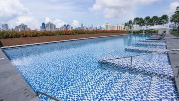 Una piscina al aire libre, sombrillas, tumbonas