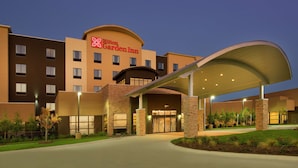 A Hilton Garden Inn with a modern design, featuring a covered entrance and landscaped surroundings.