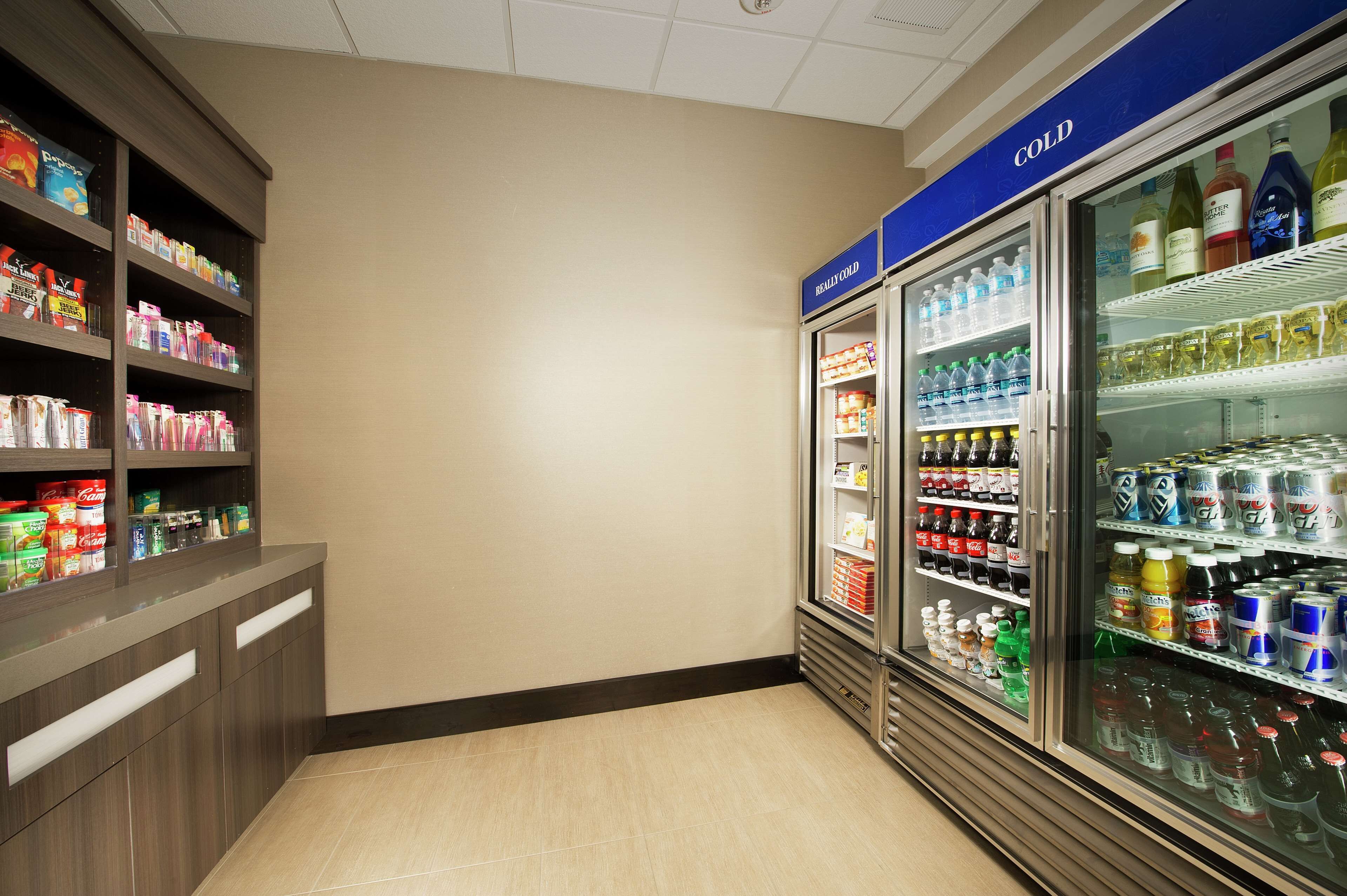 Mostrador refrigerado con diversas bebidas y aperitivos.