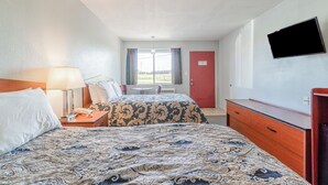 A hotel room with two beds, a TV, a desk, and a window with curtains. - Capital O Aurora Inn Monett US 60 (Aurora)