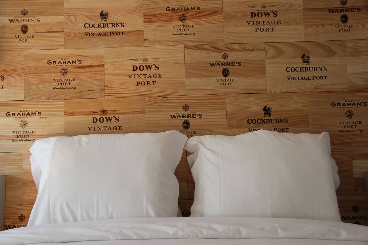 A hotel room with a wooden wall featuring vintage port labels.