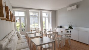 Een moderne, goed verlichte eetruimte met witte meubels en grote ramen.