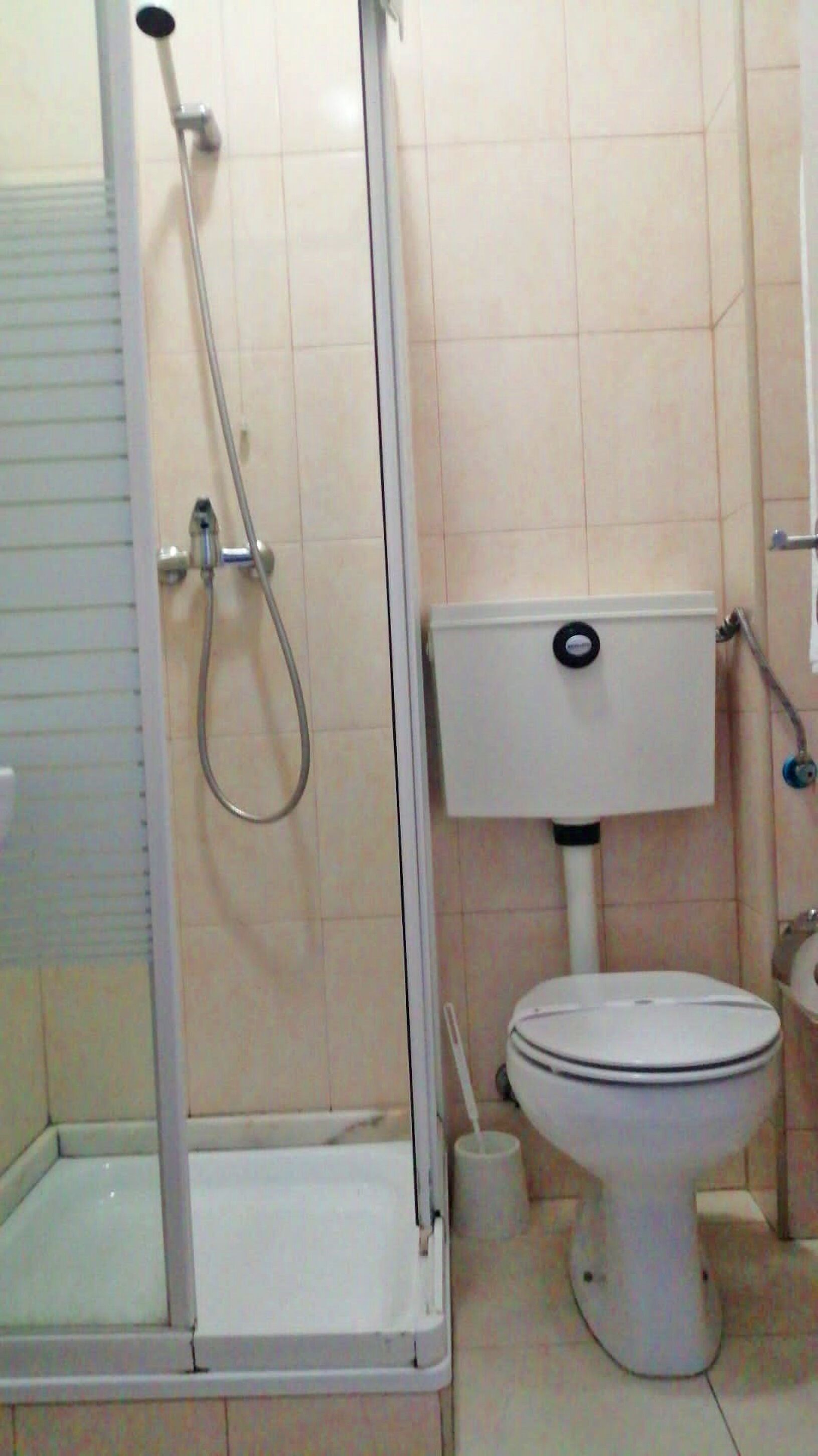 A bathroom with a shower enclosure, toilet, and a bidet.