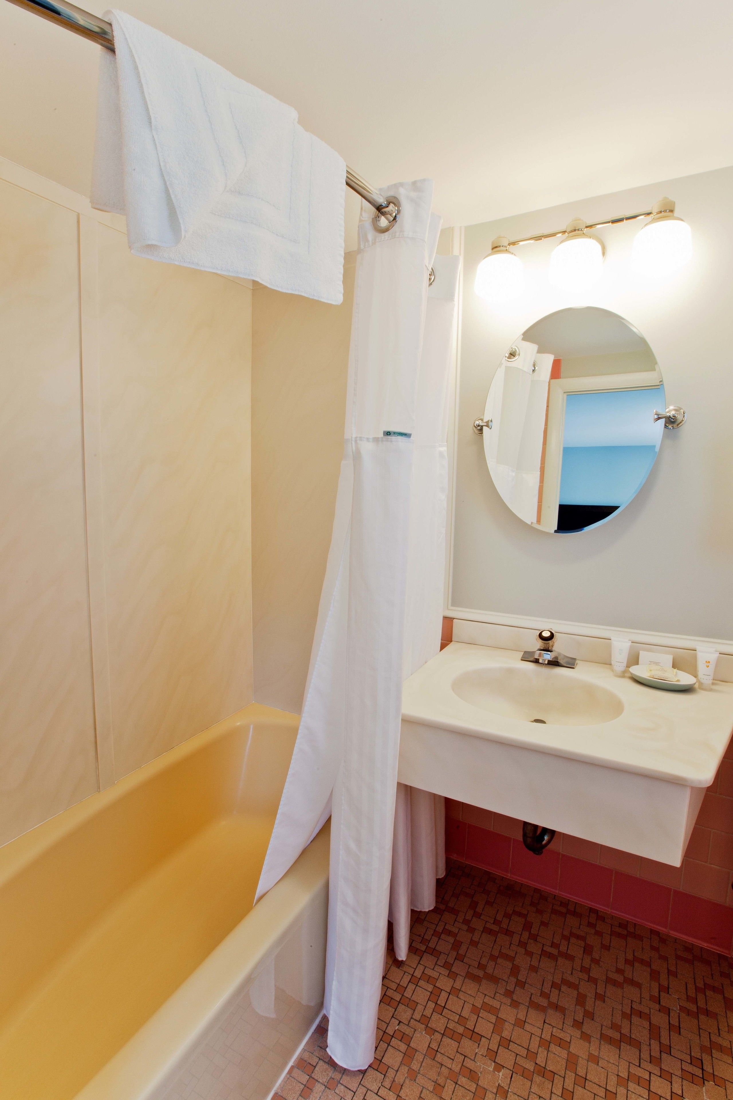 Un baño con bañera, lavamanos y espejo.