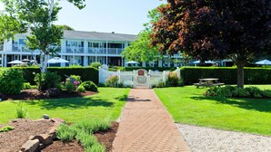 A well-maintained garden with a paved walkway leading to a building with multiple windows and balconies.
