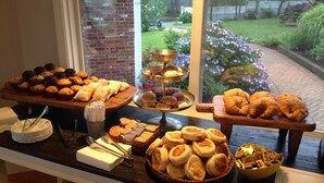 A buffet table with various baked goods and pastries.