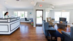 A spacious hotel lobby with a central island, seating area, and a view of the outdoors.