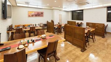 A restaurant with multiple wooden tables and chairs, a painting on the wall, and a large window.