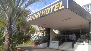 The exterior of the Sayuri Hotel with a covered entrance, stairs leading up to the entrance, and surrounding greenery. - Sayuri Hotel (Foz do Iguaçu)