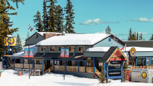 A building with a snow-covered roof, a sign for SilverStar, and a flag.