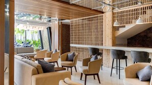 A modern lounge area with sofas, chairs, and a bar area. - Cozy Stay (Denpasar)