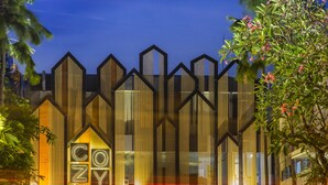 A modern hotel with a distinctive geometric facade and a prominent 'COZY' sign. - Cozy Stay (Denpasar)