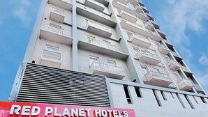 A high-rise hotel with a prominent RED PLANET HOTELS sign. - Red Planet Cagayan De Oro (Cagayan de Oro)