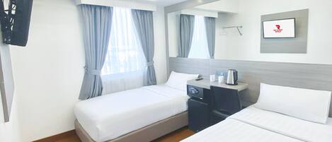 Habitación de hotel con dos camas, un escritorio, una silla, un televisor y una ventana con cortinas.
