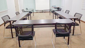 A conference room with a long table, chairs, a whiteboard, and a projector screen. - Red Planet Cagayan De Oro (Cagayan de Oro)