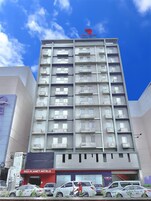 Un hotel de varios pisos con balcones y un letrero rojo para Red Planet Hotels.