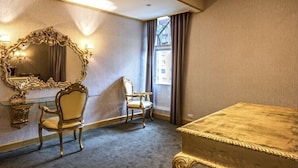 A hotel room with a large ornate mirror, two chairs, a bed, and a window with curtains. - The We Hotel (Taipei)