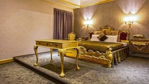 A luxurious bedroom with a large ornate bed, a gold-framed nightstand, and a matching desk. - The We Hotel (Taipei)
