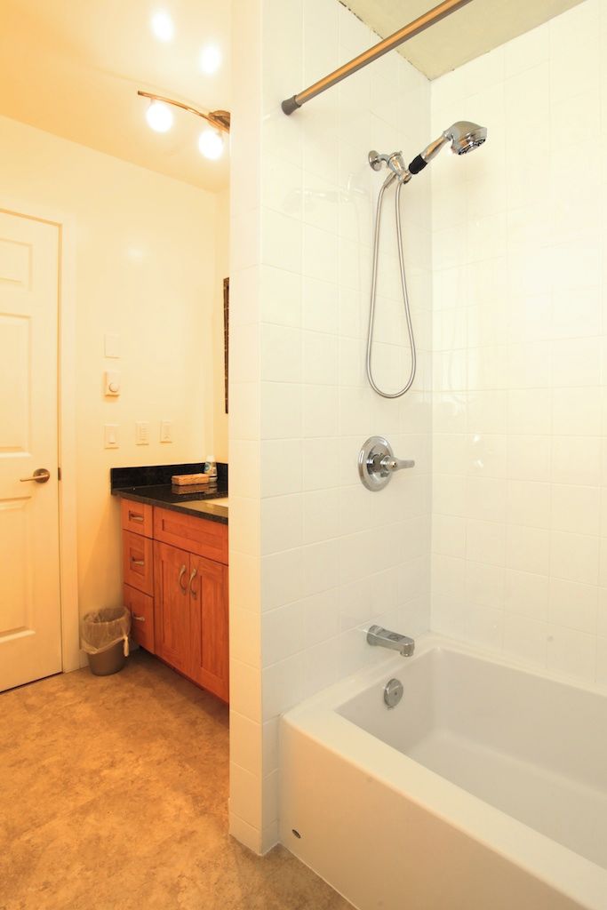 A bathroom with a bathtub, a shower, and a vanity with a sink.