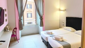 Una habitación de hotel con una cama, un escritorio, una silla y un televisor.