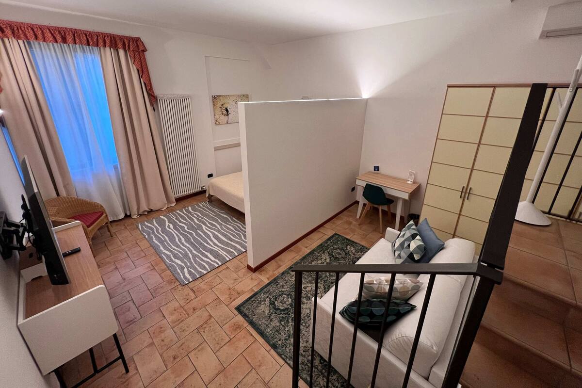 A compact room with a bed, a desk, a chair, and a wardrobe.