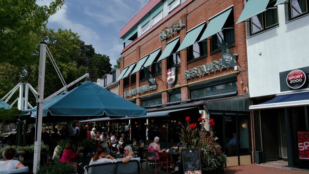 A hotel with outdoor seating and a restaurant. - Het Wapen van Elst (Elst)