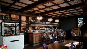 A restaurant interior with a bar area, seating, and a counter with glassware. - Het Wapen van Elst (Elst)
