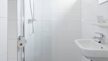 A modern bathroom with a shower, toilet, and sink.