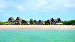 A beachfront hotel with multiple overwater bungalows, each with a thatched roof and a pool. - Maalu Maalu Resort & Spa (Pasikuda)
