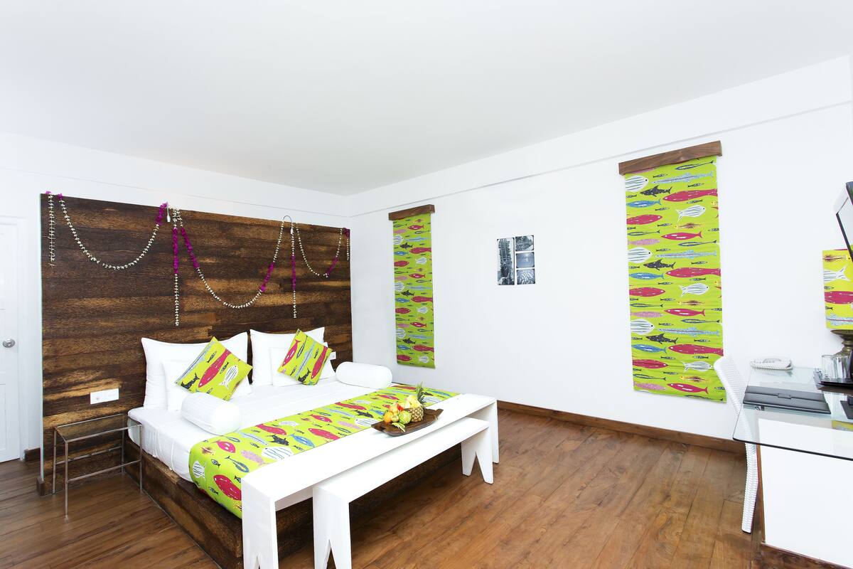 Una habitación con cama, mesita de noche y escritorio con teléfono.