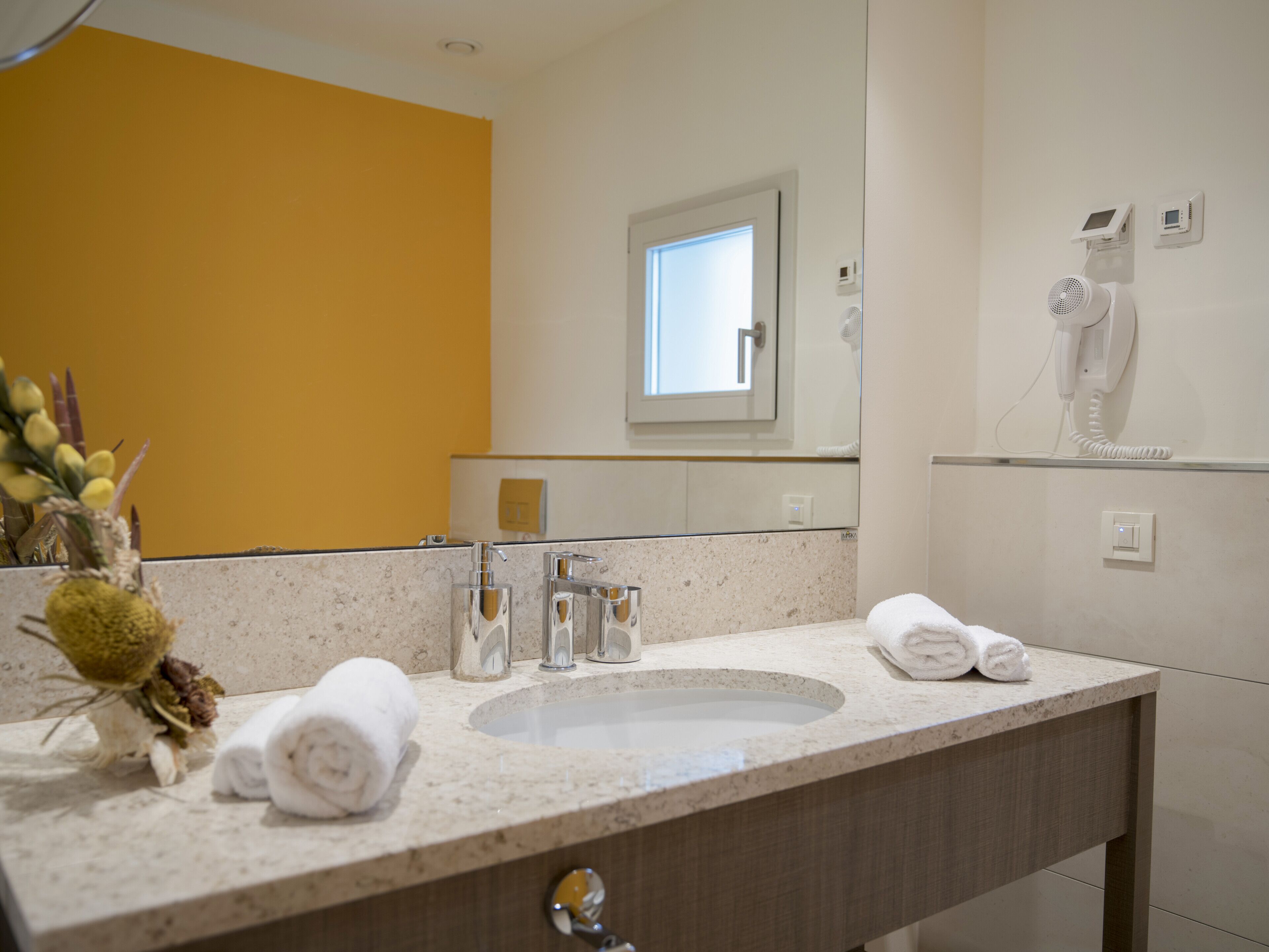 A bathroom with a sink, mirror, and towel rack.