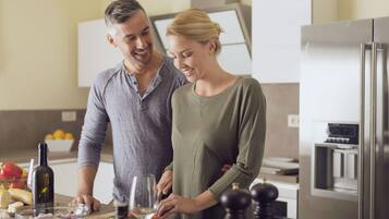 Una cocina moderna con un refrigerador de acero inoxidable, una encimera de madera y un tazón con ingredientes.