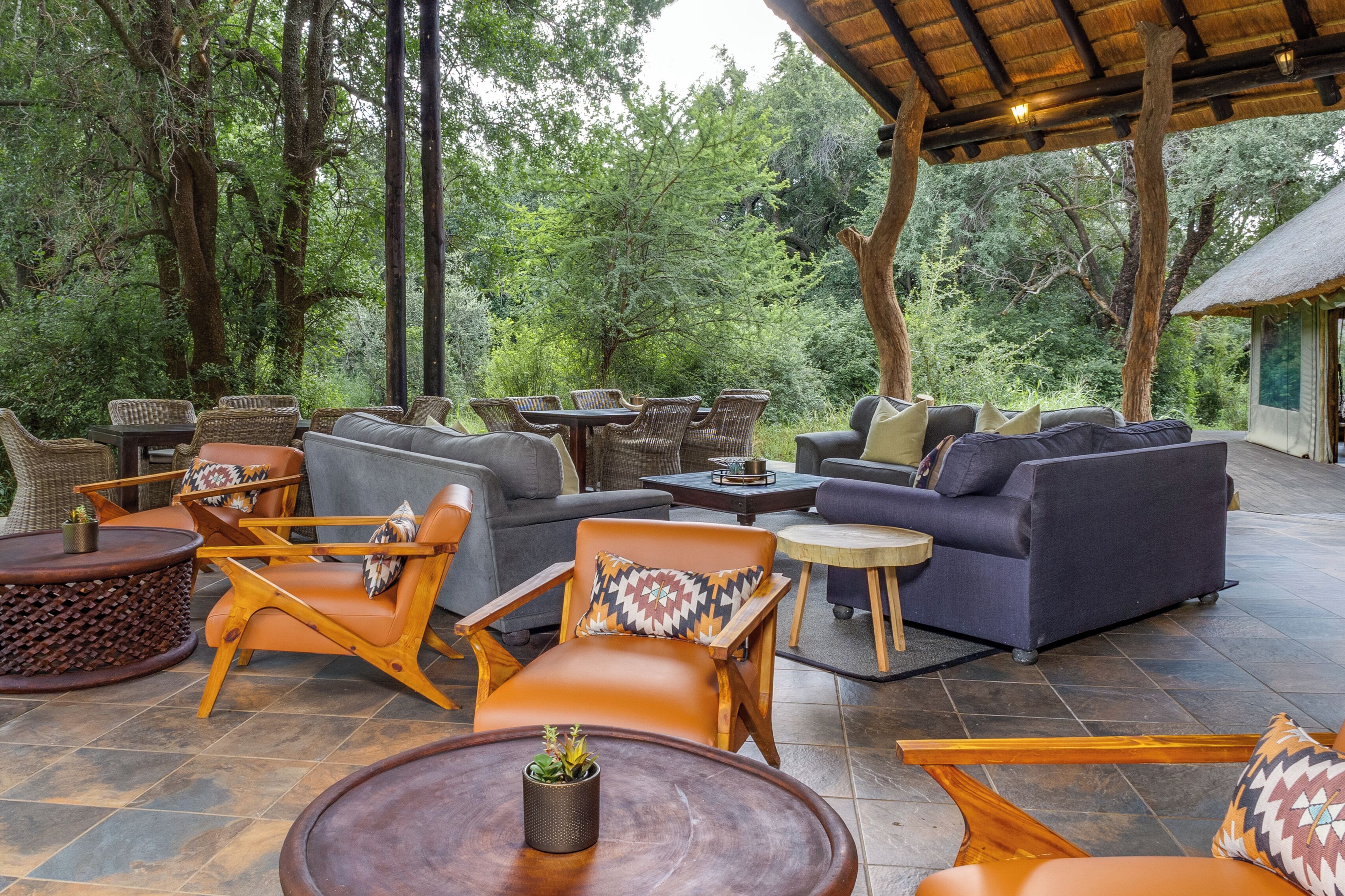 An outdoor seating area with wicker furniture and a thatched roof.