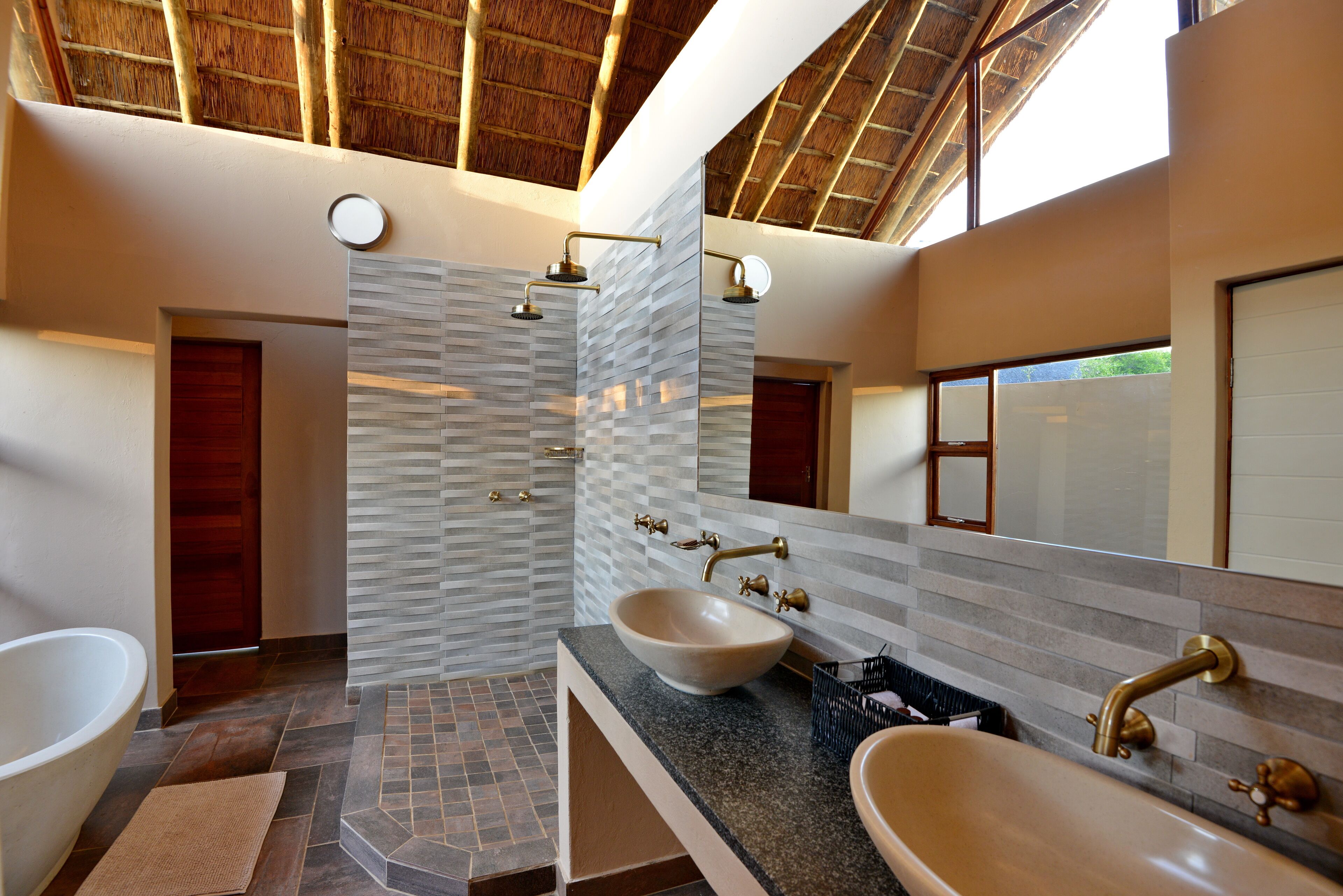 Un baño moderno con una bañera grande, dos lavabos y una ducha.