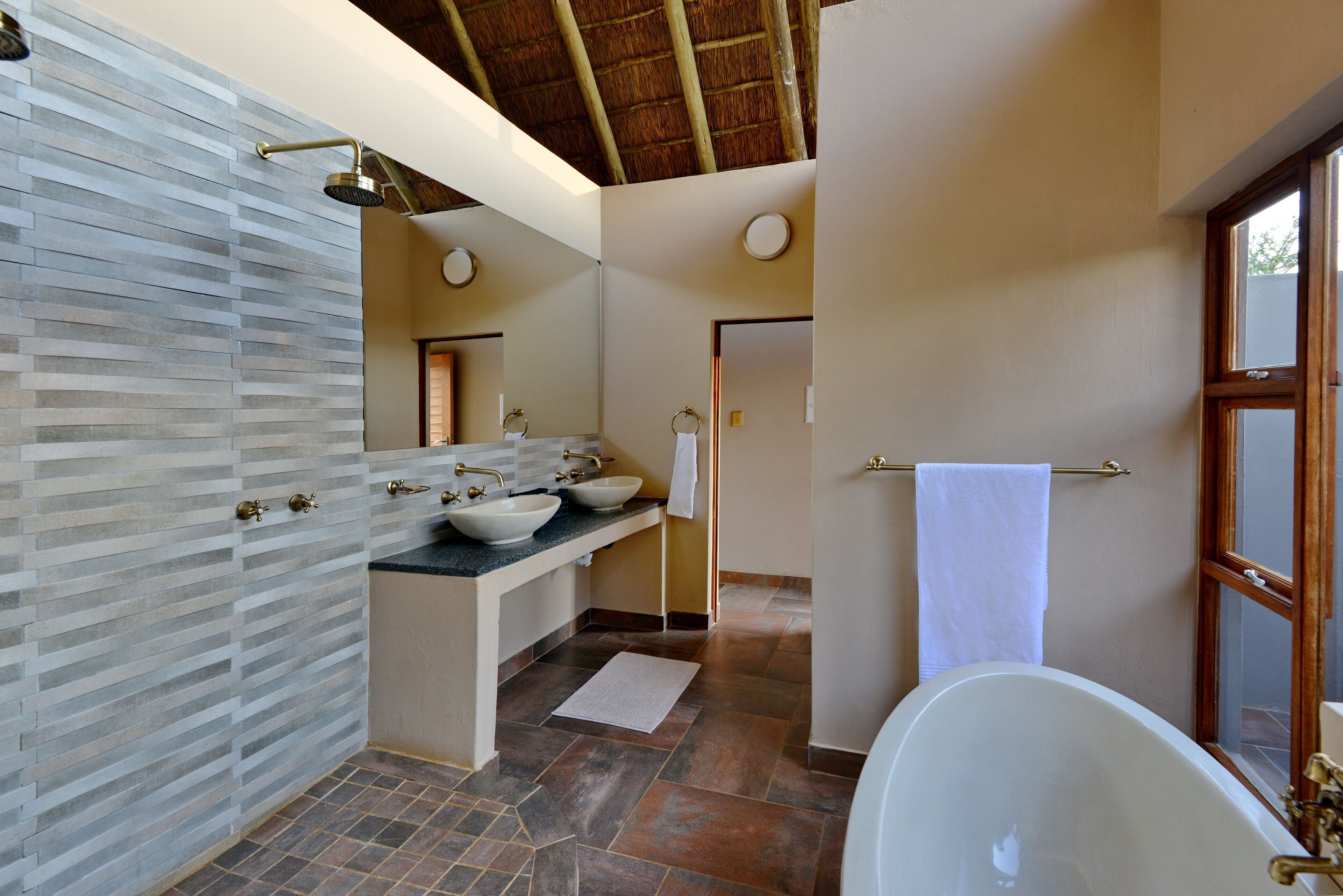 A bathroom with a large bathtub, two sinks, and a vanity with a mirror.
