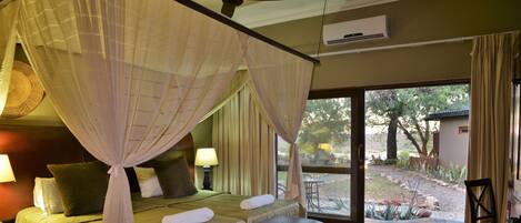 Un dormitorio con cama, mesitas de noche y ventana con vistas al exterior.