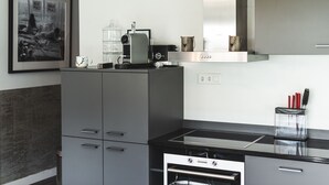 A modern kitchen with a built-in oven, a coffee maker, and a kettle on the countertop. - Haus Granit Zermatt (Zermatt)